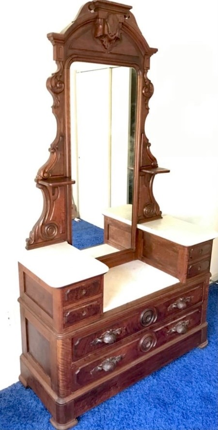A dresser with a long center mirror.
