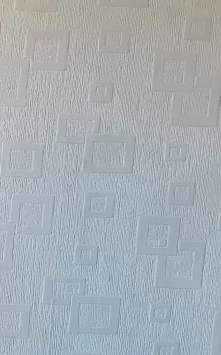 A white wallpaper with geometric designs.