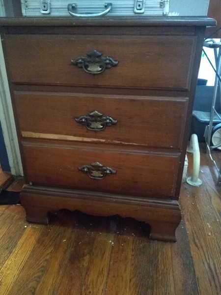 A small dresser with 3 drawers.