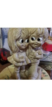 A figurine of a couple with large eyes.
