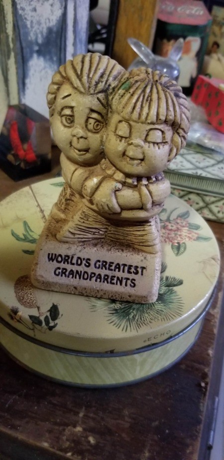 A figurine of a couple saying "World's Greatest Grandparents."