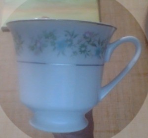 A china cup with flowers around the rim.
