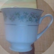 A china cup with flowers around the rim.