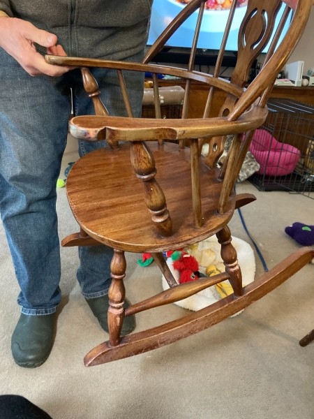 The wooden rocking chair from the side.