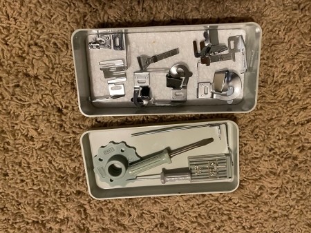 Tools stored inside a sewing machine.