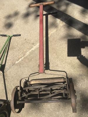 An old reel mower on a driveway.