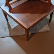 The side of an end table with a triangular shelf.
