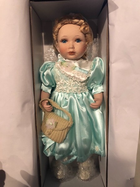 A porcelain doll in a box.