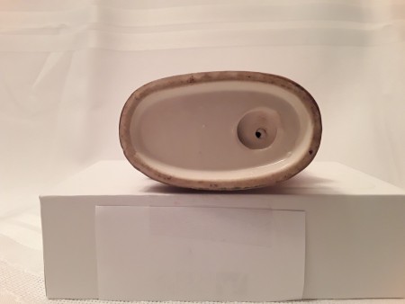 The bottom of a ceramic figurine.