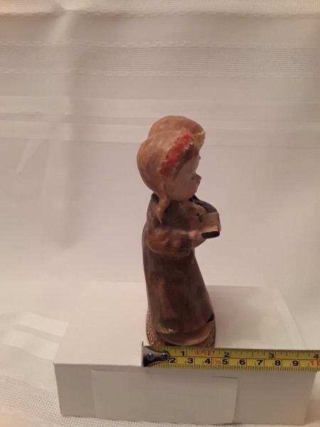 A figurine of two girls, measuring 2 inches front to back.