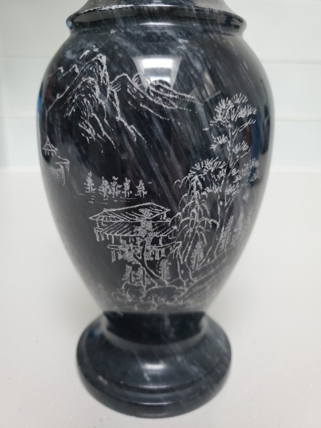 A marble stone vase with carvings.