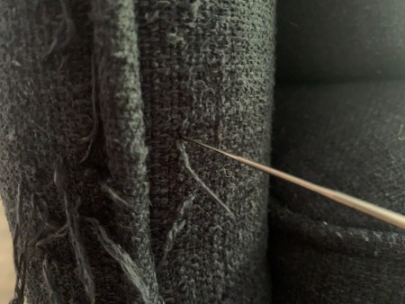 Using a felting needle to push back in strings.