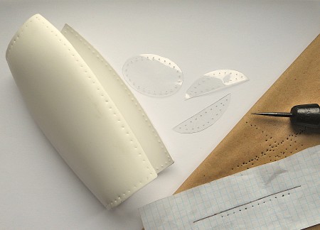 Poking holes into the pieces of plastic.