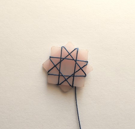 Wrapping thread around the star shape.