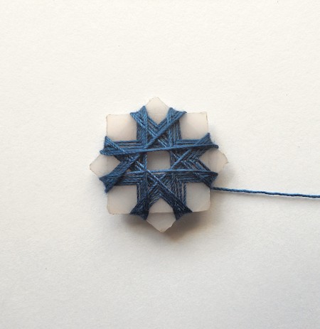 Wrapping thread around the star shape.