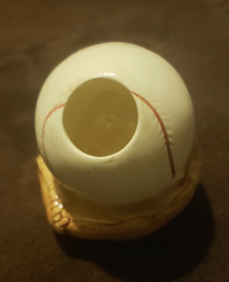 A hole in the top of the ceramic baseball.