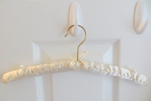 A satin hanger with pearl buttons on the shoulders.