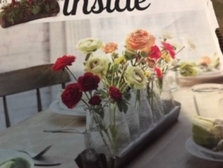 Recycled bottles with flowers in a magazine.