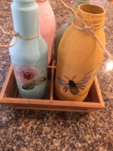 Placing the painted and decorated bottles in a container with 4 sections.