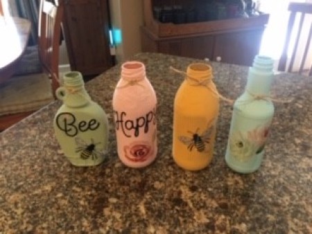 Four differently shaped bottles painted and decorated.