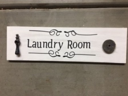 Adding plumbing parts to a Laundry Room sign.