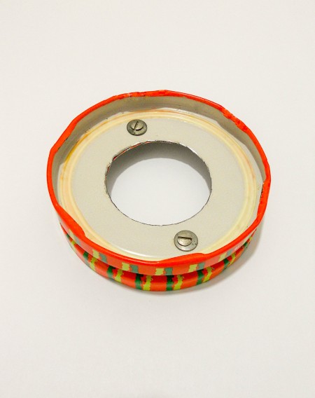 Attaching the two painted metal lids together.