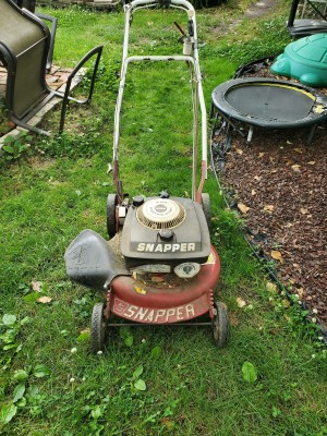 A lawnmower in a yard.