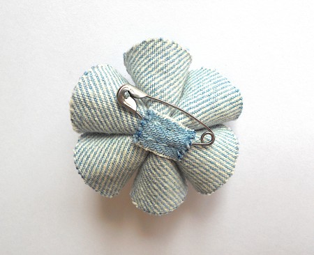 Adding a safety pin to the back of the flower.