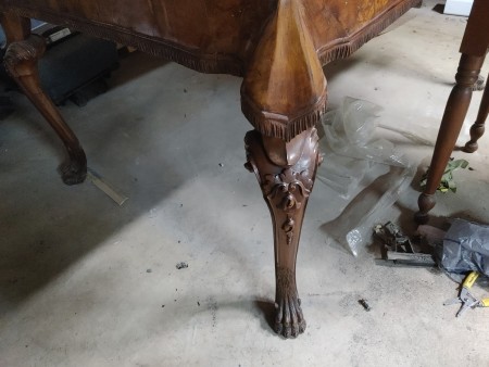 The carved leg of a wooden table.
