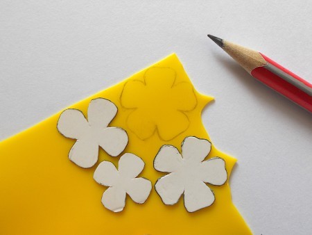 Tracing the flower shapes onto the recycled plastic pieces.