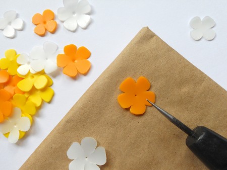 Adding a hole to the center of the plastic flowers.