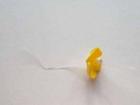 Adding a pearl to the center of the flowers.