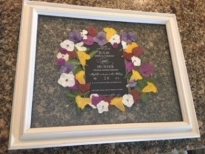 A wedding announcement surrounded by dried flowers.
