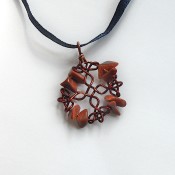 The completed pendant on a ribbon.