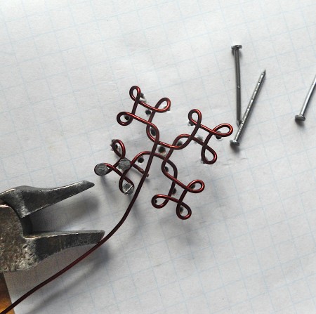 Weaving wire around the nails.