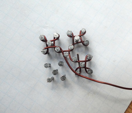 Weaving wire around the nails.