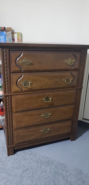 A wooden dresser with 5 drawers.