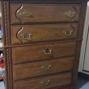 A wooden dresser with 5 drawers.