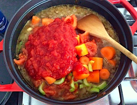 Adding tomato to pot.