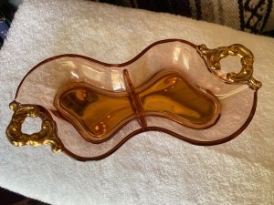 A glass dish with gold handles.
