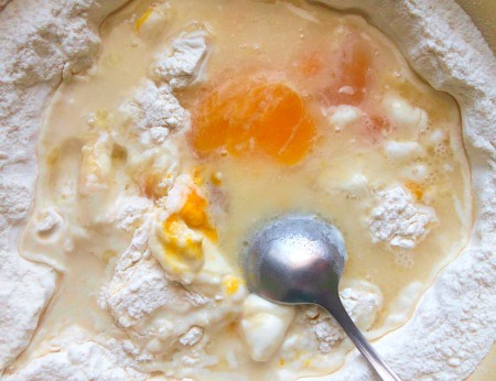 Mixing the eggs and flour together.