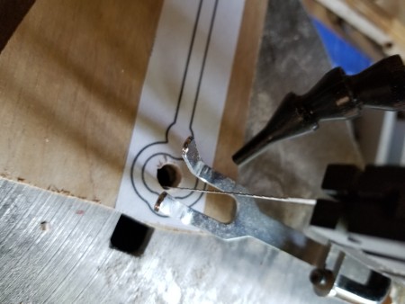 Using a jigsaw to cut out the skeleton key shapes.