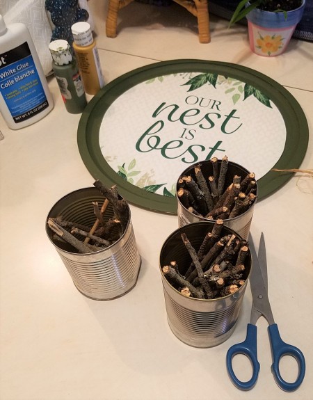 A collection of twigs in recycled cans.