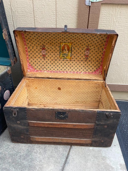 An open wooden steamer trunk.