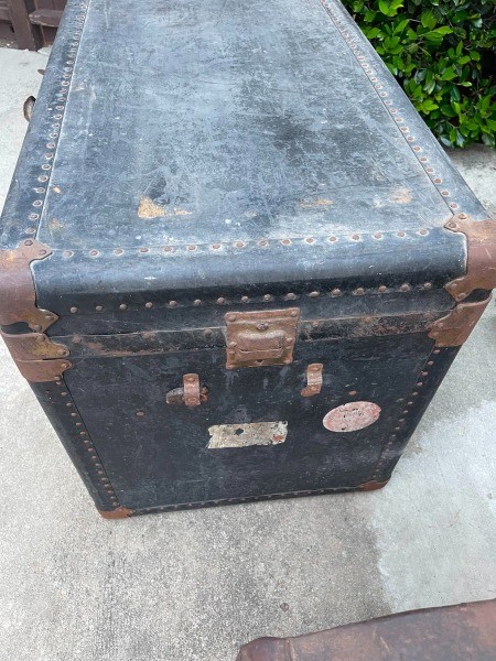 An old dark colored steamer trunk.
