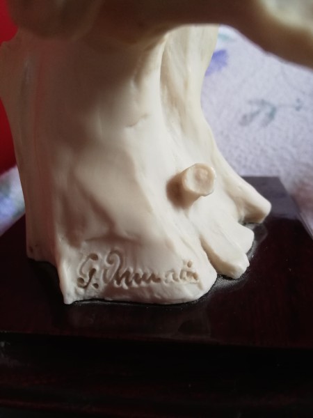 The marking on the bottom of the sculpture.