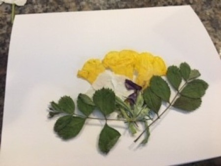 Decorating the card with greenery and flowers.