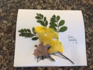 Decorating the card with greenery and flowers.