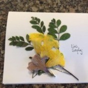 Decorating the card with greenery and flowers.