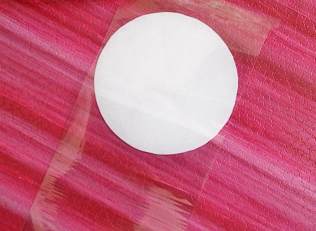 Cutting out circles of transparent duct tape.